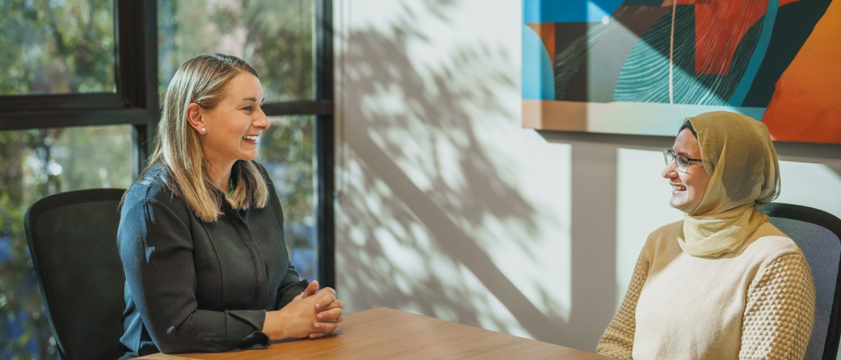 Renae speaking with a client in a meeting room, amd